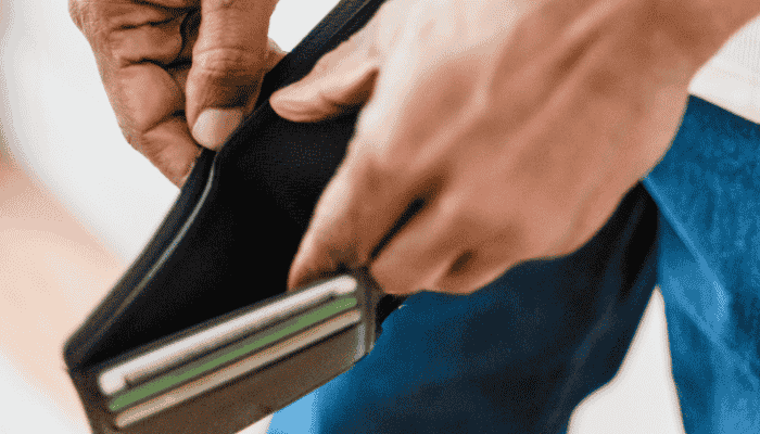 close up of man with hands inside an empty wallet