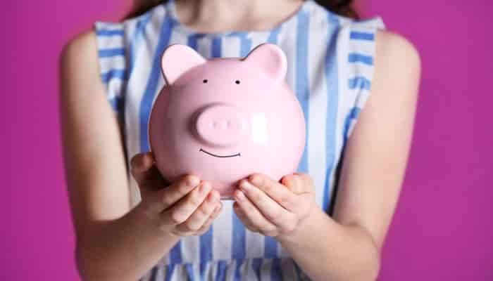 girl holding a piggy bank