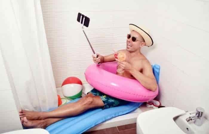 man with swim ring taking selfie in bathroom