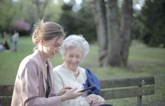 young and old woman looking at phone