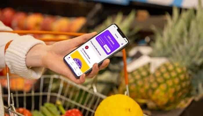 my Nectar prices on a phone held in front of fruit