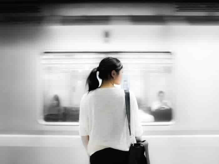 woman looking at a train speeding past