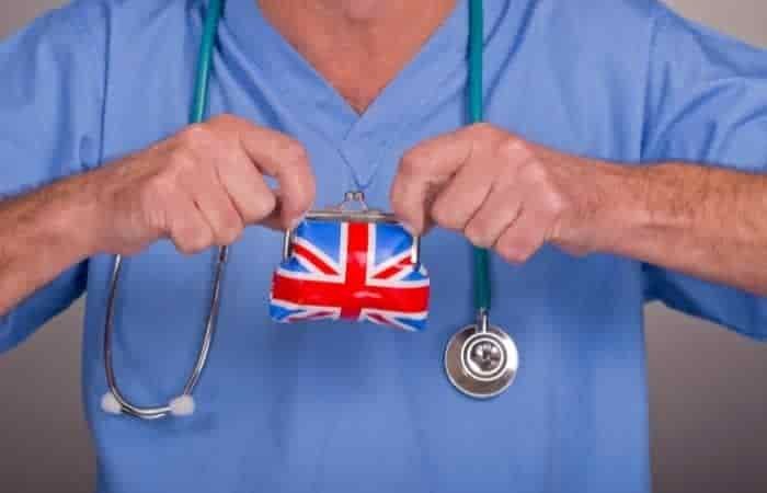 doctor in scrubs with aa stethescope holding a union jack purse