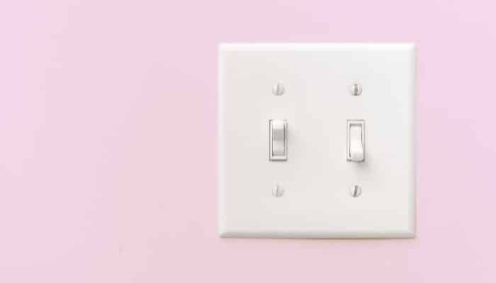 dual light switch on a pink wall