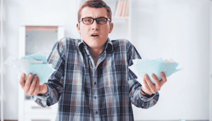 confused man holding pieces of green paper