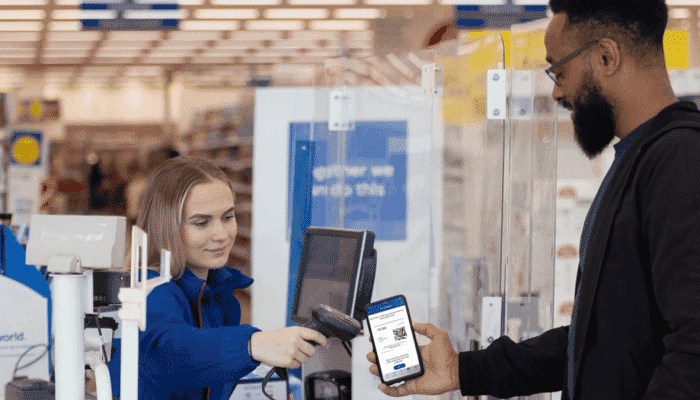 Man showing QR code of Tesco Clubcard while at the till
