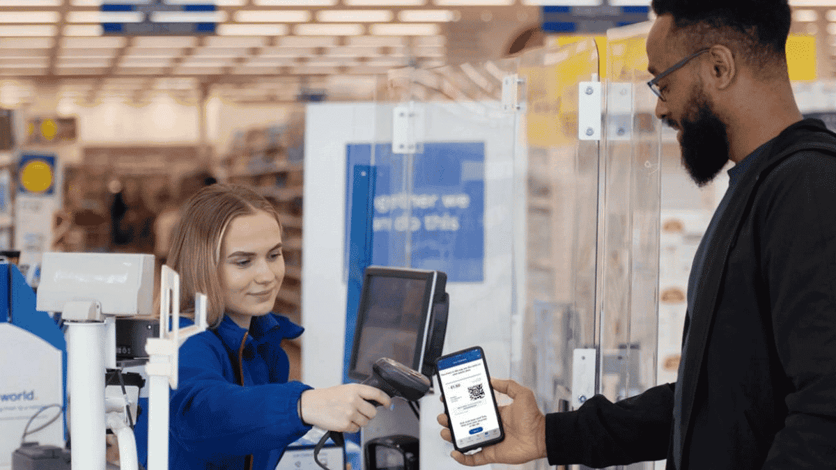 Man showing QR code of Tesco Clubcard while at the till