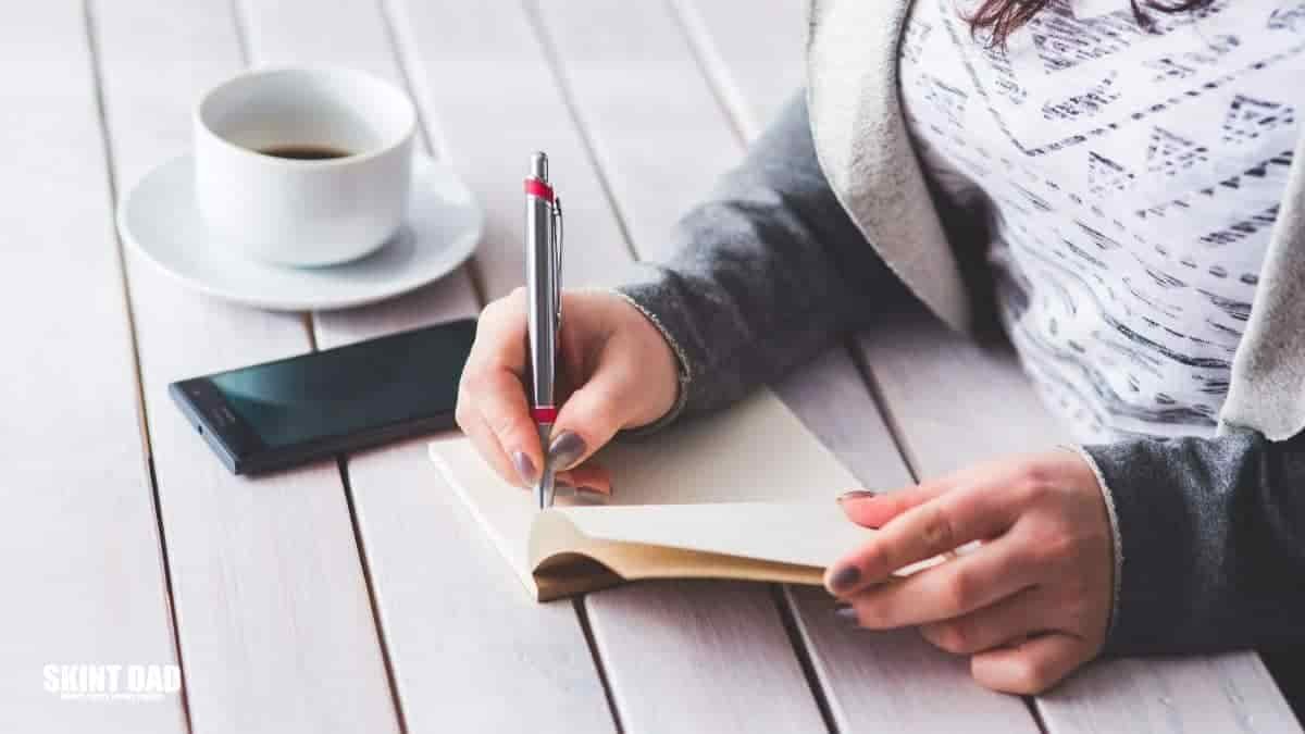 woman writing in notepad